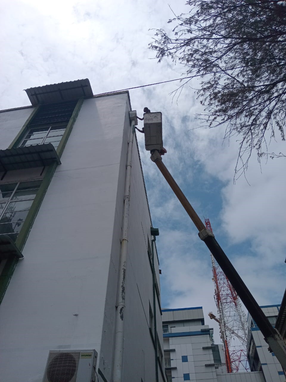 Close-up of a worker in a crane lift working on the upper exterior wall